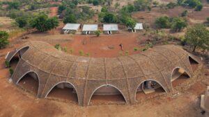 Stone-covered roof provides "absolute camouflage" for Gamaya Farms eco-resort in India